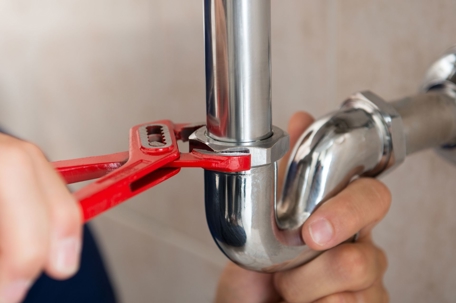 man working under sink